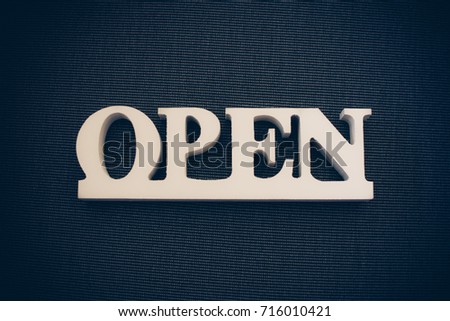 Open sign made of wood on black background