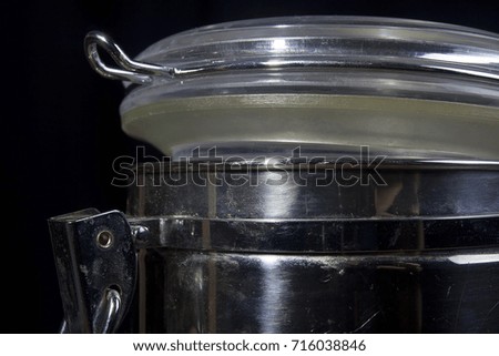 Metal container with a tight lid on a black background