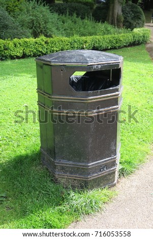 Black rubbish litter trash bin in UK park isolated photograph