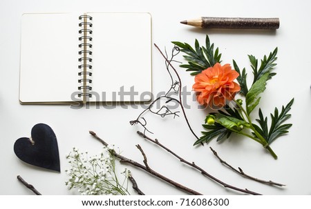 Creative layout of accessories, flowers and a notebook on a white background. A bright and stylish concept. View from above.