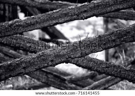 black charred beam with nails on it, black and white photo.
