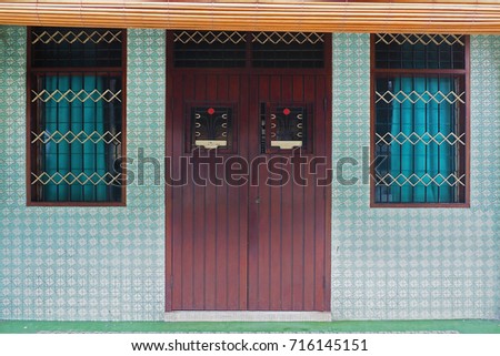 clean vintage traditional asian house wooden door with green tile wallpaper in Penang Malaysia