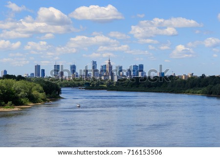 Warsaw skyline with skyscrapers and the Vistula River under the cloudy sky