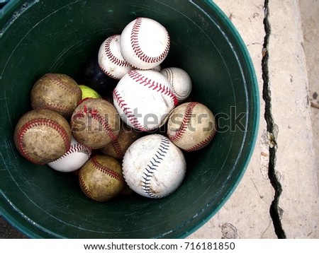 Photo of a bucket of old and new baseball