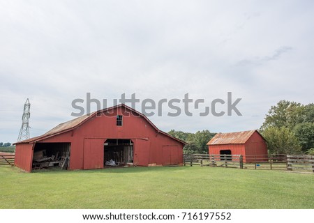 Beautiful red barn in a green, grassy field in rural, upstate South Carolina.