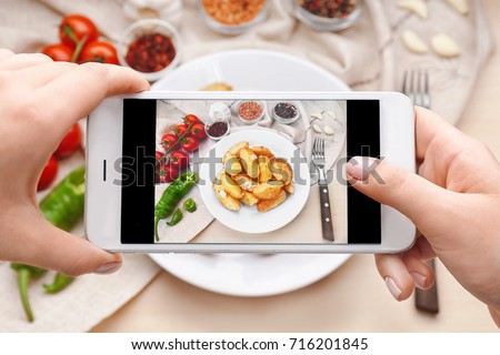 Female hands taking photo of food with mobile phone