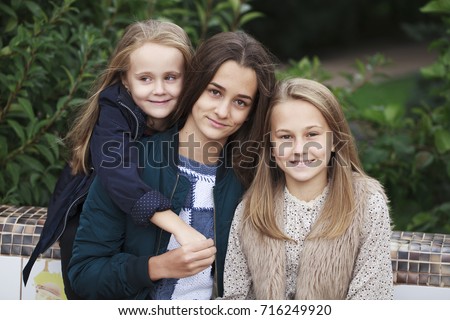 Close up portrait of three native sisters against the background of the autumn park
