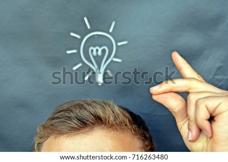 head in front of a board with a bulb drawn on it