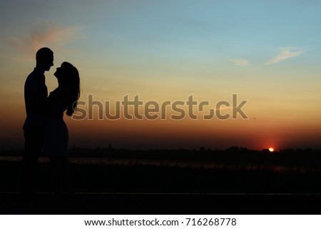 Silhouette of young couple being tender