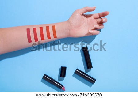 Lipstick makeup swatches on female hand, flat lay