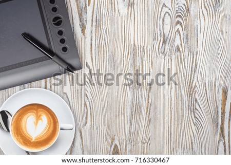 notebook with pencils and graphic tablet with coffee on a wooden background