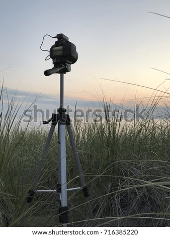 Camera on a tripod on the beach at sunset