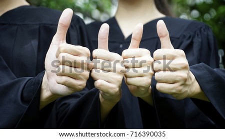 thumb up hands or like hands with black gown .