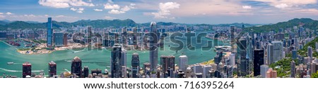 Wide panorama of Hong Kong skyline from Victoria Peak on a sunny day