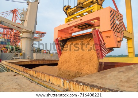 Sugar bulk load into vessel at loading port. Bulk cargo handling and loading concept for port operation Royalty-Free Stock Photo #716408221