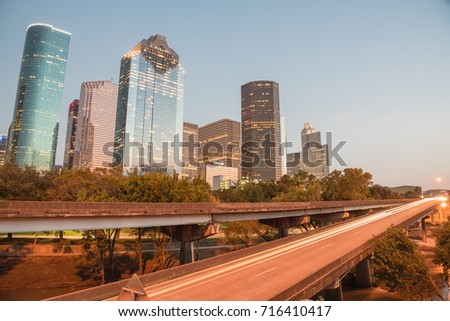 Downtown Houston from Buffalo Bayou Park at twilight. Highway car light trails in front and skyscrapers from central business district in background. Transportation, architecture and travel concept.