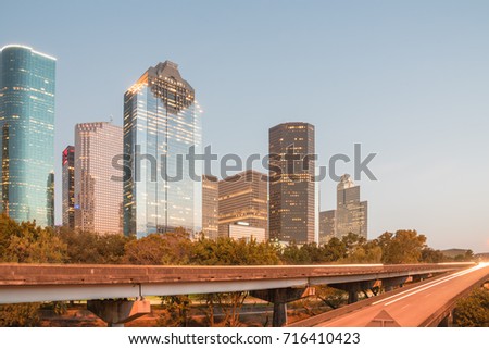 Downtown Houston from Buffalo Bayou Park at twilight. Highway car light trails in front and skyscrapers from central business district in background. Transportation, architecture and travel concept.