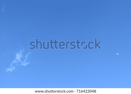Clear blue sky with small thin cloud and moon