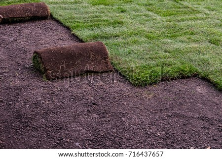 Roll of sod om sodding installation work site Royalty-Free Stock Photo #716437657