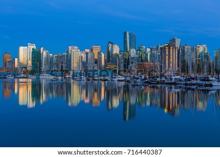 Vancouver British Columbia Canada city skyline by the marina during evening blue hour with water reflection