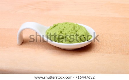 plate with Japanese wasabi sauce on wood background.