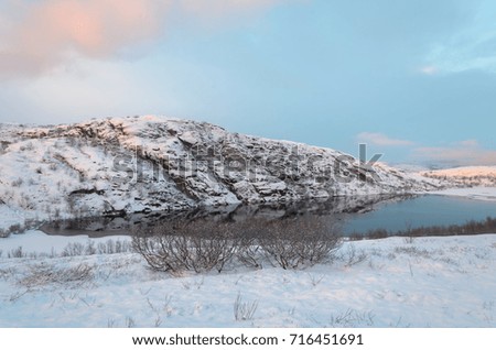 Hills , tundra in winter and lake water.