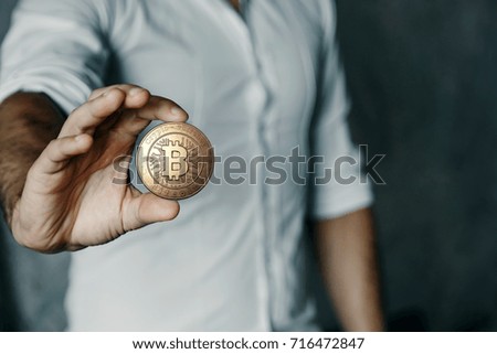 Gold coin Bitcoin in the hand.. The concept of crypto currency. Blockchain technology. Mixed media.