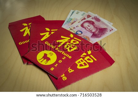 The red envelope or hong bao is used for giving money during Chinese New Year in China and Taiwan.2018 is the dog's year. Chinese words meaning Good fortune a dog's silhouette on it and yuan bills.