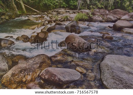 A toned image of a small waterfall in a tropical country.