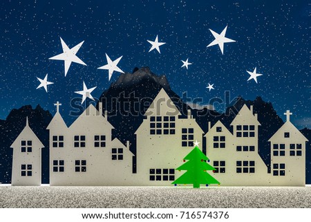 Silhouette of a small village at winter time in the night. With stars and snow in the sky