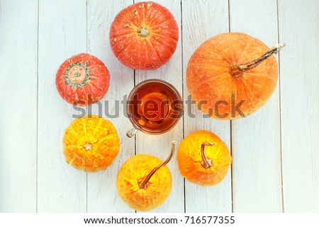 Autumn still life with Colorful pumpkin and cup of tea on white wooden table.  fall season, thanksgiving holiday, Halloween concept. copy spase. top view