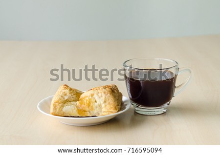 Black coffee and pie on wooden base