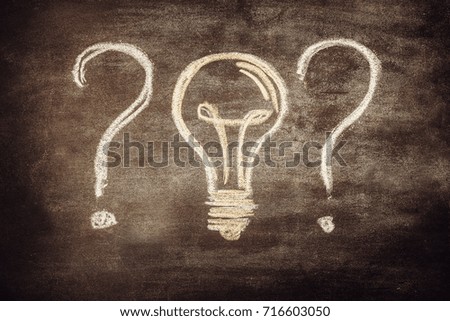 Question sign with bulb on chalk board. Toned photo.