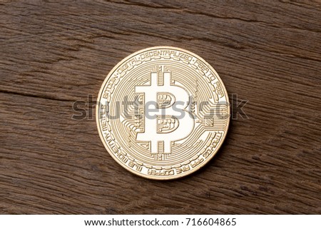 Golden bitcoin on wooden background. High resolution photo.