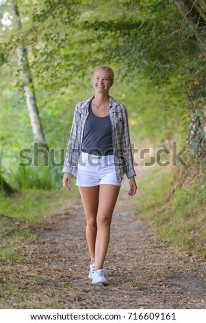 blond haired woman walking in the forest