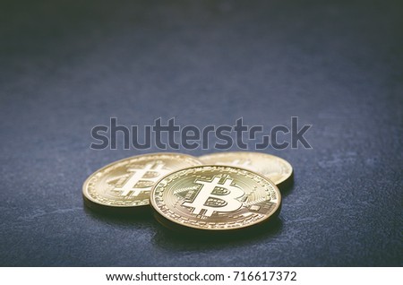 Golden bitcoin coins on a dark background with reflection. Virtual currency. Crypto currency. New virtual money. Lens flare