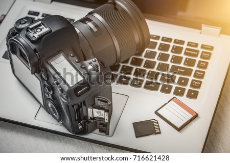 Modern digital DSLR camera and computer workstation. Photography and videography concept.