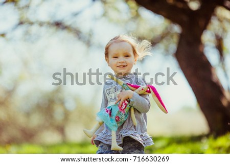 Girl walks with toy under the trees