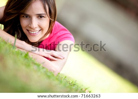 Beautiful girl lying on the floor outdoors and smiling