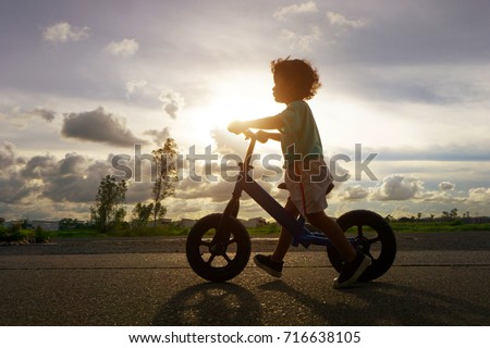 Asian kid first day play balance bike. Little boy learning to ride with bicycle. 
