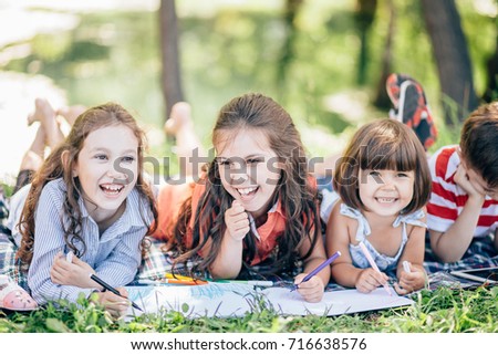 group of little girls and boy painting with paintbrush and colorful paints Royalty-Free Stock Photo #716638576