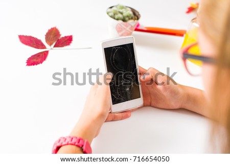 Girl using a phone with broken screen