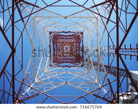 Communication tower with sun blue sky background Royalty-Free Stock Photo #716675764