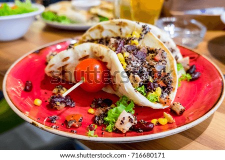 Mexican spicy taco with beans, chicken, cheese, tomato salsa, cabbage served at the restaurant of Novi Sad, Serbia