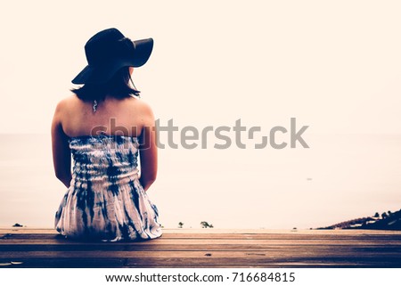 Back view of woman in relaxing beside the sea on Tropical Resort. Exotic Paradise. Travel, Tourism and Vacations Concept.