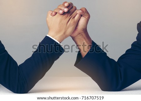 Businessman Holding Each Other Hands Over Desk, arm wrestling