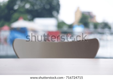 Blur image of wooden table and chair in cafe with outdoor background