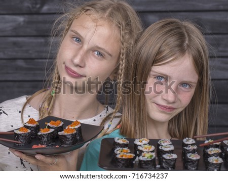 Two teen girl with sushi roll close up portrait, teenage girls eating japanese sushi