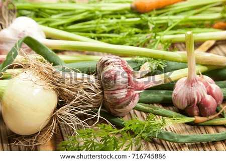 Fresh vegetables, garlic on a rustic wooden background. View from above.