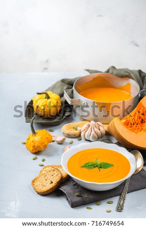Food and drink, still life, diet and nutrition concept. Seasonal fall autumn roasted orange pumpkin carrot soup with ingredients on a table. Copy space cozy background